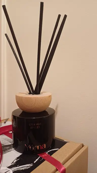Μαύρο γυάλινο reed diffuser της YUMA με ξύλινο καπάκι και μαύρα στικς αρώματος Orange Spices.