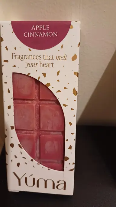 Συσκευασία Apple Cinnamon της YUMA με κόκκινα wax melts σε σχήμα σοκολάτας και χρυσές λεπτομέρειες.