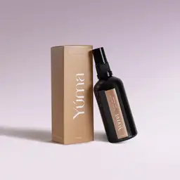 Μαύρο μπουκάλι fabric mist Black Orchid της YUMA δίπλα στην μπεζ χάρτινη συσκευασία του.