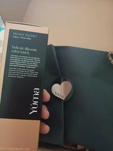Κοντινό πλάνο της συσκευασίας Peony Velvet Fabric / Room Mist της YUMA δίπλα σε μαύρο κουτί.