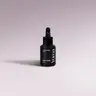 Μαύρο μπουκάλι Car Diffuser Refill Black Orchid της YUMA με σταγονόμετρο σε λιλά φόντο.