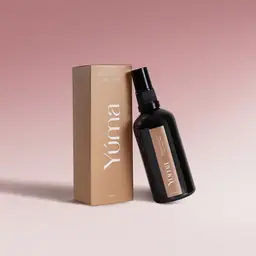 Μαύρο μπουκάλι Fabric Mist Peony Velvet της YUMA δίπλα στην μπεζ χάρτινη συσκευασία του.