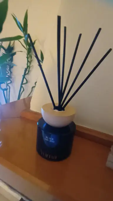 Reed diffuser της YUMA σε άρωμα Black Orchid με μαύρα στικ και ξύλινο καπάκι.