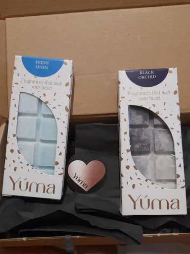 Δύο συσκευασίες wax melts της YUMA σε αρώματα Fresh Linen και Black Orchid μέσα σε κουτί.