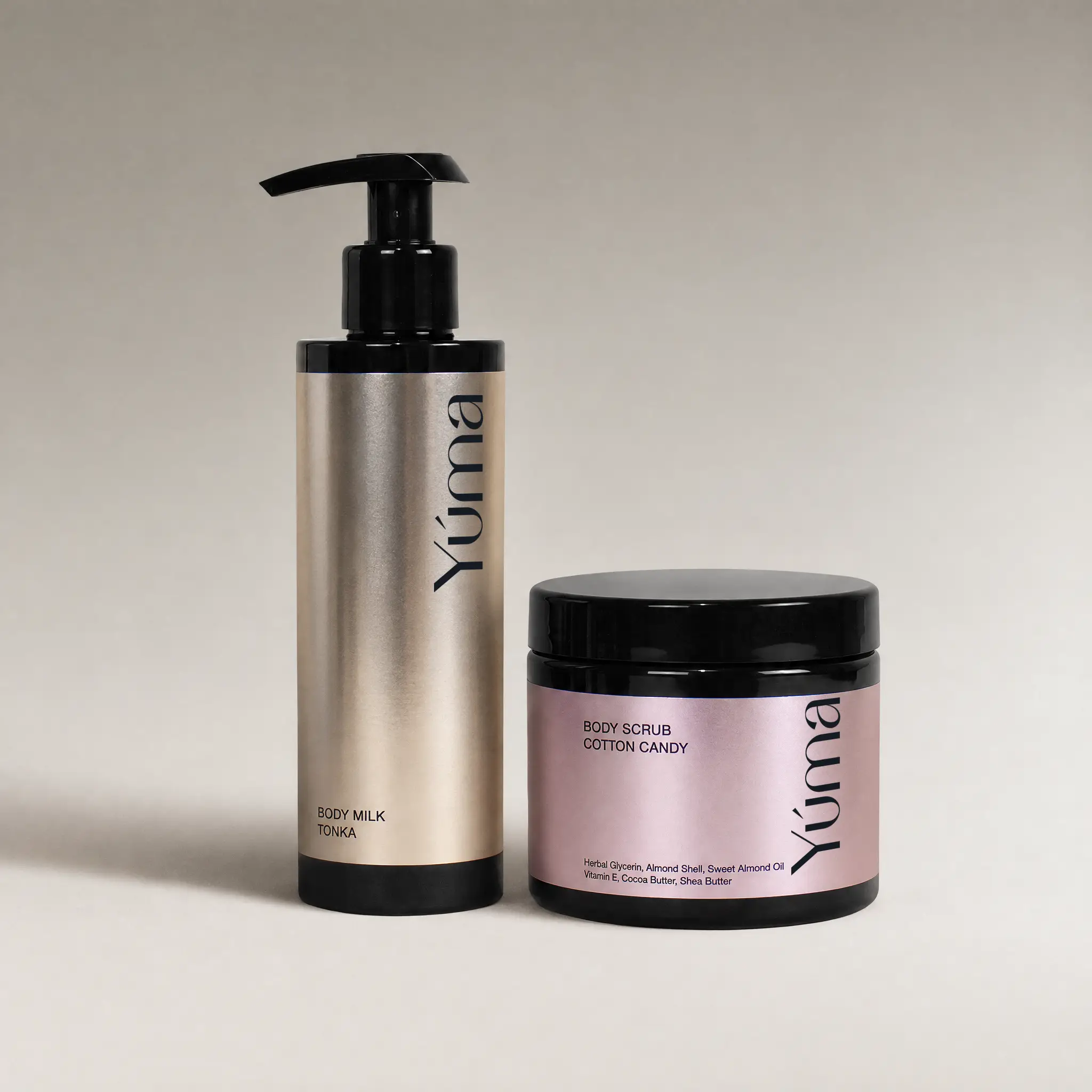 Body milk Tonka και body scrub Cotton Candy της Yúma σε ουδέτερο φόντο.
