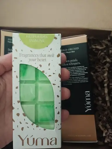 Πράσινη μπάρα wax melt Hesperides Jasmine της YUMA μέσα σε λευκή συσκευασία με παράθυρο.