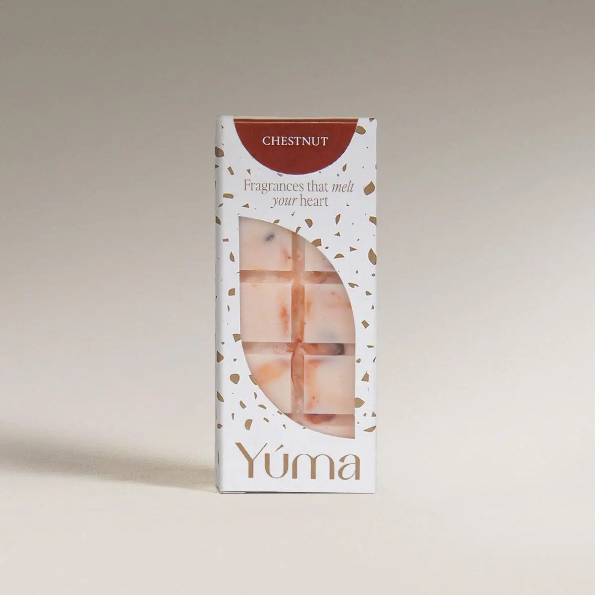 Λευκή συσκευασία YUMA για wax melts Chestnut με άνοιγμα που αποκαλύπτει την ανάγλυφη μπάρα κεριού.