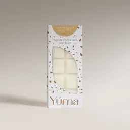 Λευκή συσκευασία Wax Melts Caramelized Popcorn της YUMA με καφέ λεπτομέρειες και ορατούς κύβους κεριού.