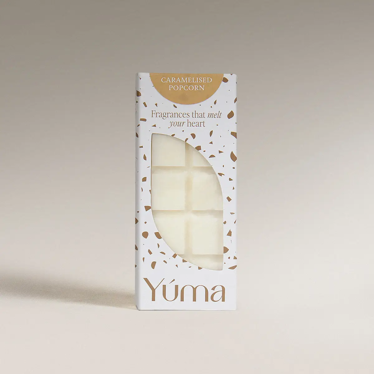Λευκή συσκευασία Wax Melts Caramelized Popcorn της YUMA με καφέ λεπτομέρειες και ορατούς κύβους κεριού.