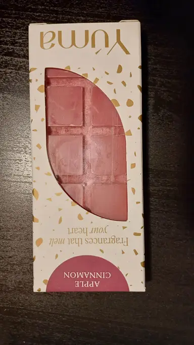 Ροζ wax melt σε σχήμα σοκολάτας μέσα σε λευκή συσκευασία της YUMA με χρυσές λεπτομέρειες.