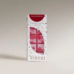 Λευκή συσκευασία Melomakarono wax melts της YUMA με κόκκινα και ροζ αρωματικά κεριά σε σχήμα σοκολάτας.
