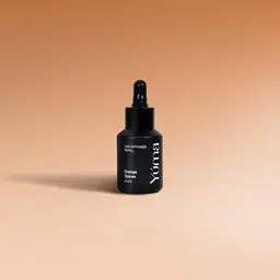 Μαύρο μπουκάλι Car Diffuser Refill της YUMA με άρωμα Orange Spices σε μπεζ φόντο.
