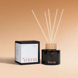 Reed diffuser Pumpkin Pie της YUMA σε σκούρο γυάλινο μπουκάλι δίπλα στη χάρτινη συσκευασία του.