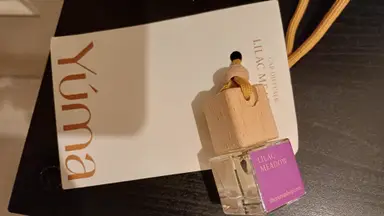 Μικρό γυάλινο μπουκαλάκι Car Diffuser Lilac Meadow της YUMA με ξύλινο πώμα και κίτρινο κορδόνι.