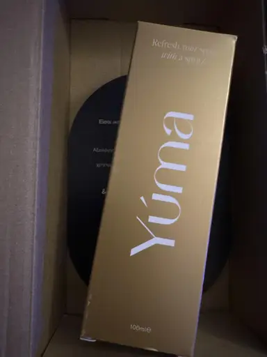 Χρυσή ορθογώνια συσκευασία της YUMA με λευκά γράμματα μέσα σε χάρτινο κουτί αποστολής.