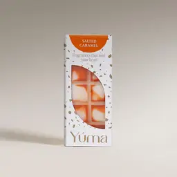 Λευκή συσκευασία wax melts Salted Caramel της YUMA με πορτοκαλί λεπτομέρειες σε ουδέτερο φόντο.