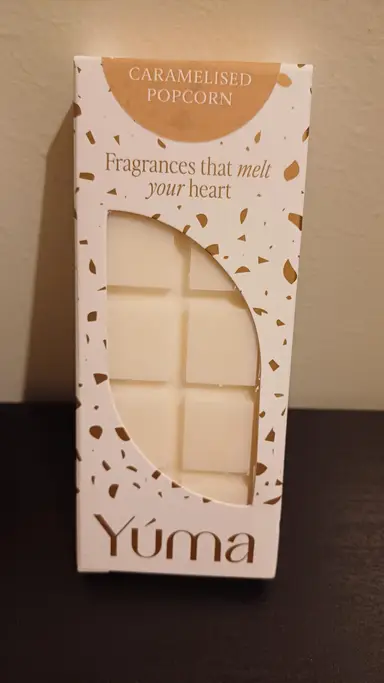 Λευκή συσκευασία wax melt Caramelised Popcorn της YUMA με χρυσές λεπτομέρειες και ορατά τετράγωνα κεριού.