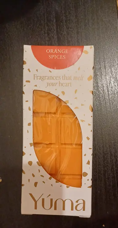 Πορτοκαλί wax melt της YUMA σε λευκή συσκευασία με χρυσές λεπτομέρειες και την επιγραφή Orange Spices.