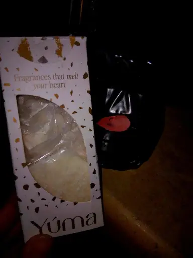Συσκευασία YUMA με wax melts δίπλα σε έναν μαύρο κεραμικό καυστήρα με αναμμένο ρεσό.