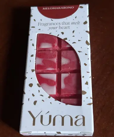 Λευκή συσκευασία YUMA για wax melts με άρωμα MELOMAKARONO που περιέχει κόκκινη και λευκή ανάγλυφη πλάκα κεριού.