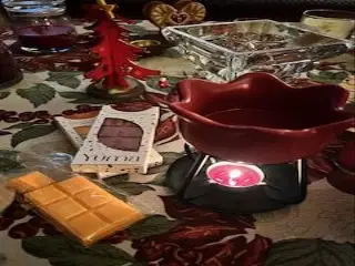 Κεραμικός καυστήρας με αναμμένο ρεσό δίπλα σε wax melts της YUMA πάνω σε γιορτινό τραπεζομάντηλο.
