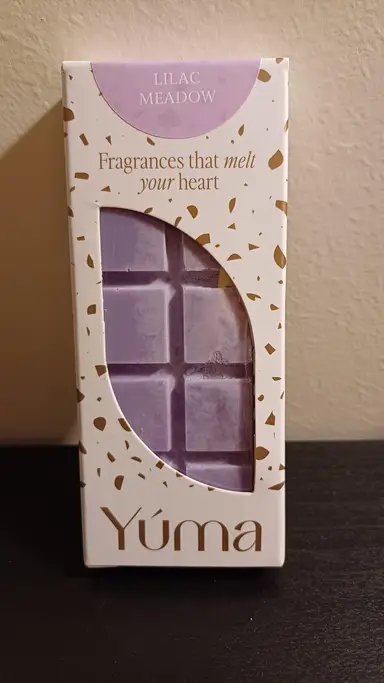 Μωβ wax melt σε σχήμα σοκολάτας μέσα σε λευκή συσκευασία YUMA με χρυσές λεπτομέρειες.