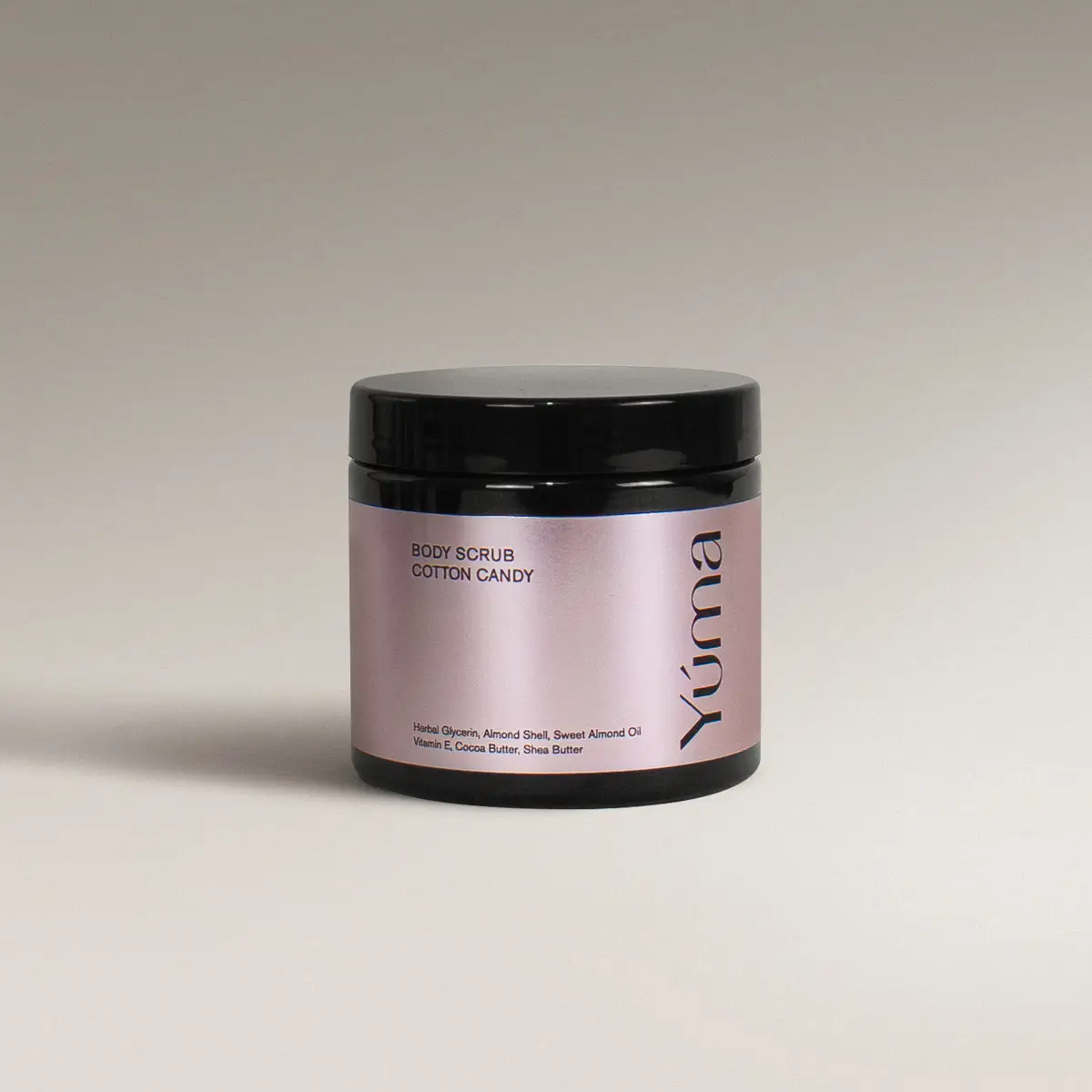 Μαύρο βάζο Body Scrub Cotton Candy της YUMA με ροζ μεταλλική ετικέτα σε γκρι φόντο.
