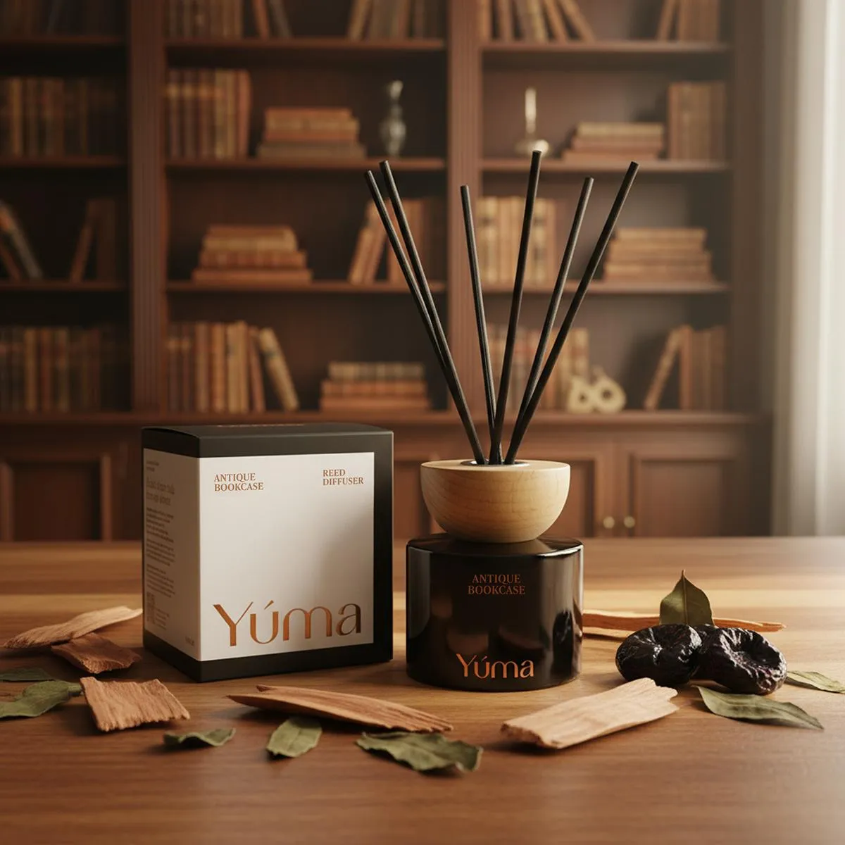 Reed diffuser Antique Bookcase της YUMA με μαύρα στικς δίπλα στη συσκευασία του σε ξύλινο τραπέζι.