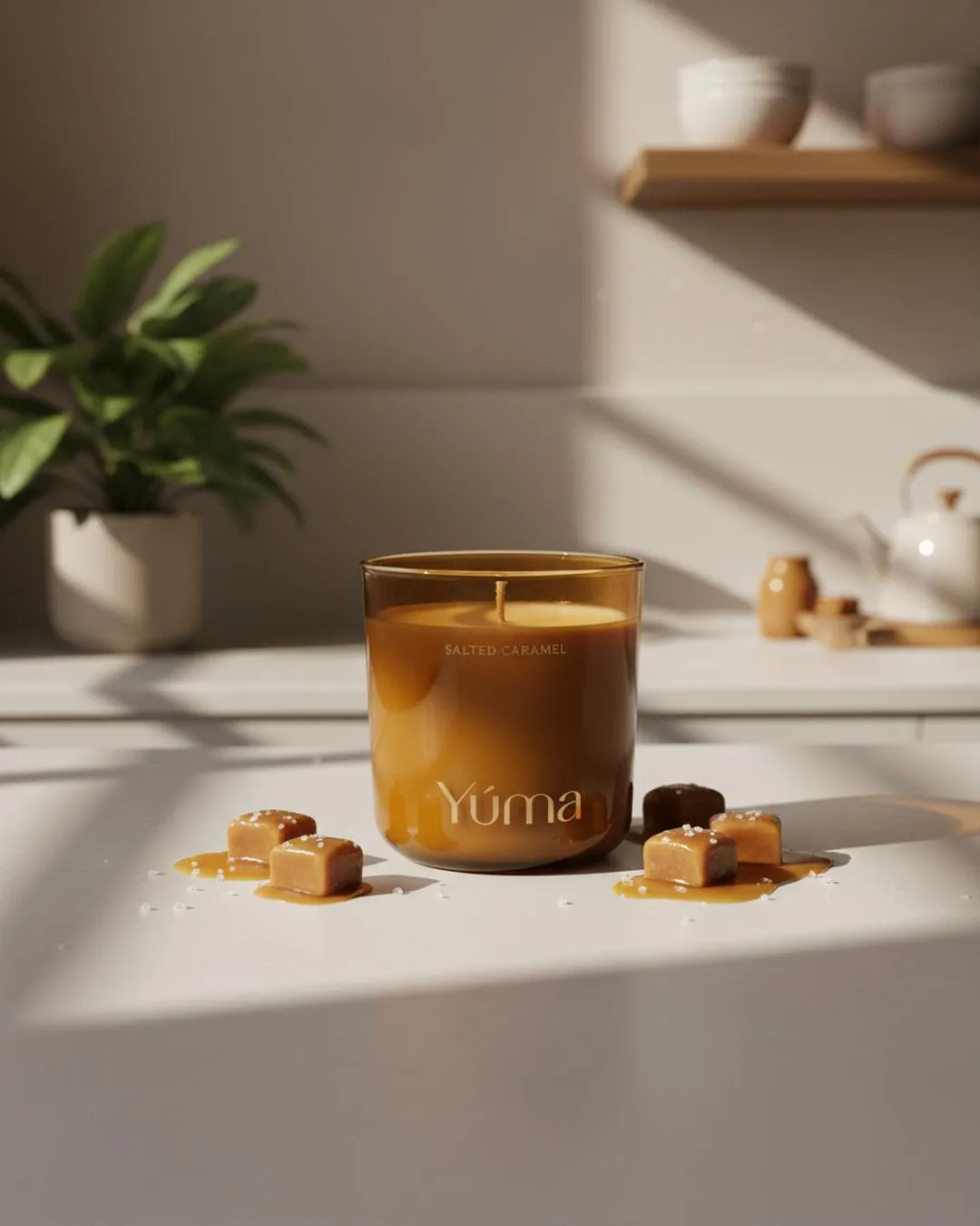 Κερί Salted Caramel της YUMA σε καφέ γυάλινο δοχείο ανάμεσα σε κύβους καραμέλας και κόκκους αλατιού.