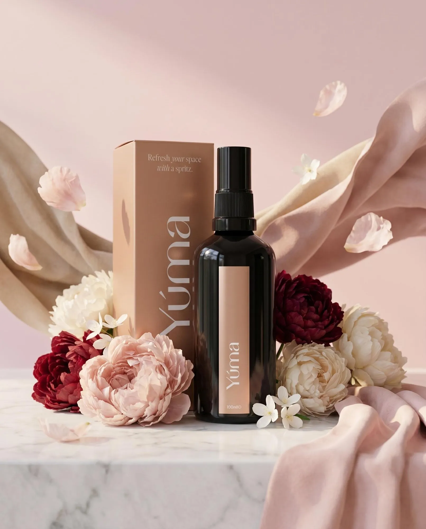 Μαύρο μπουκάλι room spray Peony Velvet της YUMA ανάμεσα σε παιώνιες και απαλά υφάσματα.