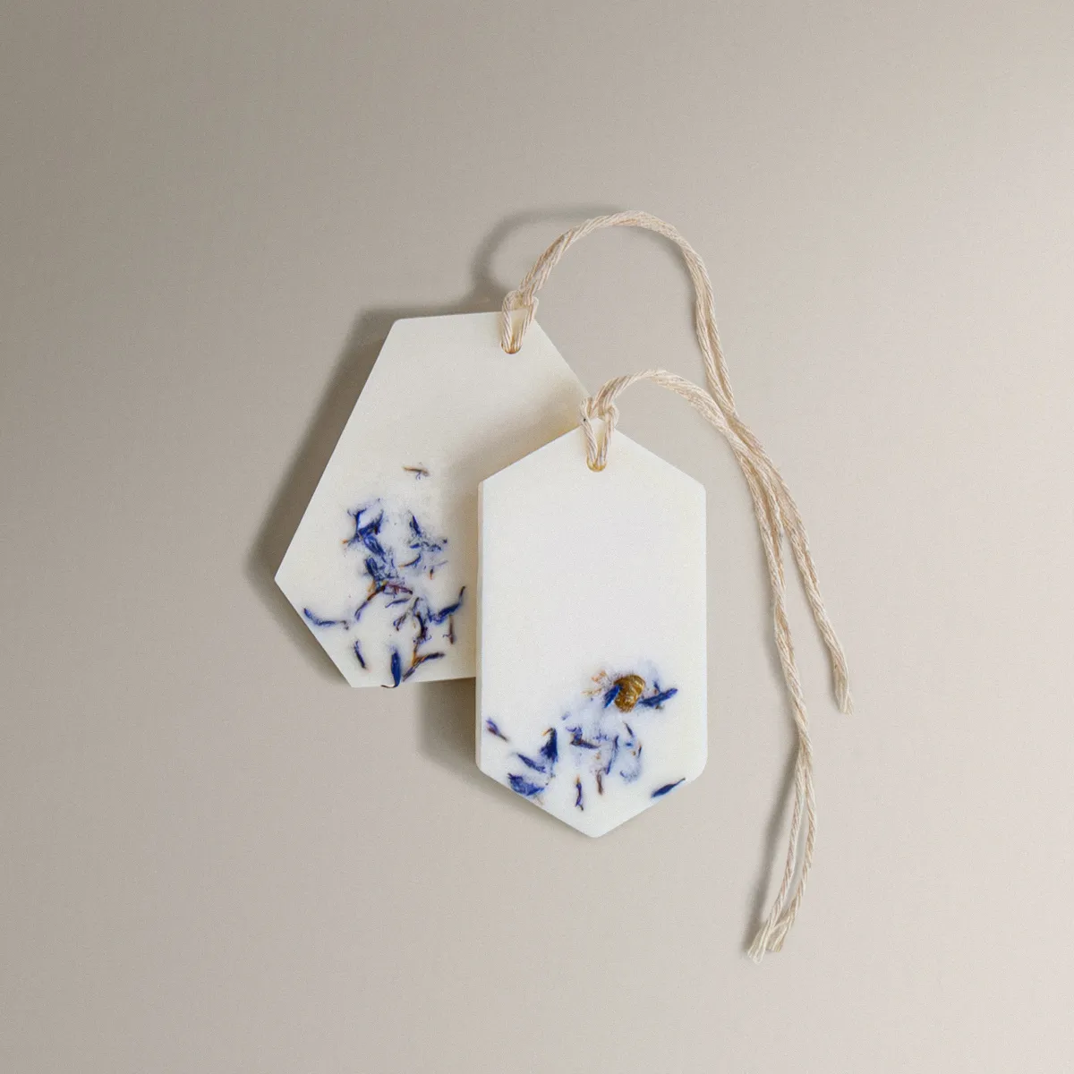 Δύο λευκά Fresh Linen Wax Tablets με μπλε αποξηραμένα άνθη και σπάγκο.