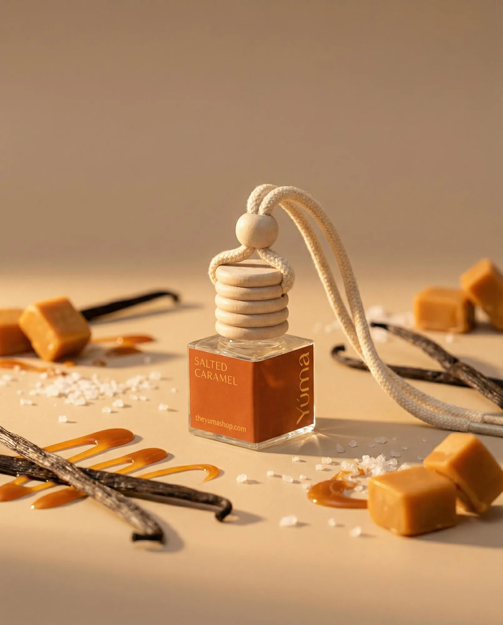 Car Diffuser της YUMA με άρωμα Salted Caramel ανάμεσα σε κύβους καραμέλας, κόκκους αλατιού και στικ βανίλιας.