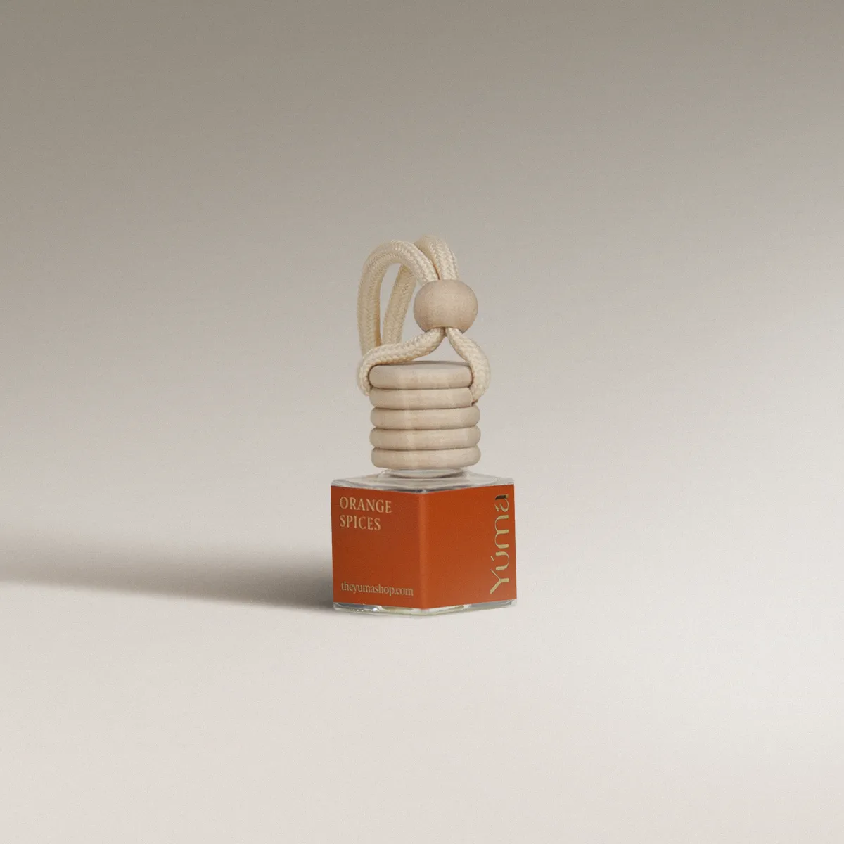 Γυάλινο Car Diffuser της YUMA με άρωμα Orange Spices, πορτοκαλί ετικέτα και ξύλινο πώμα με σχοινί.
