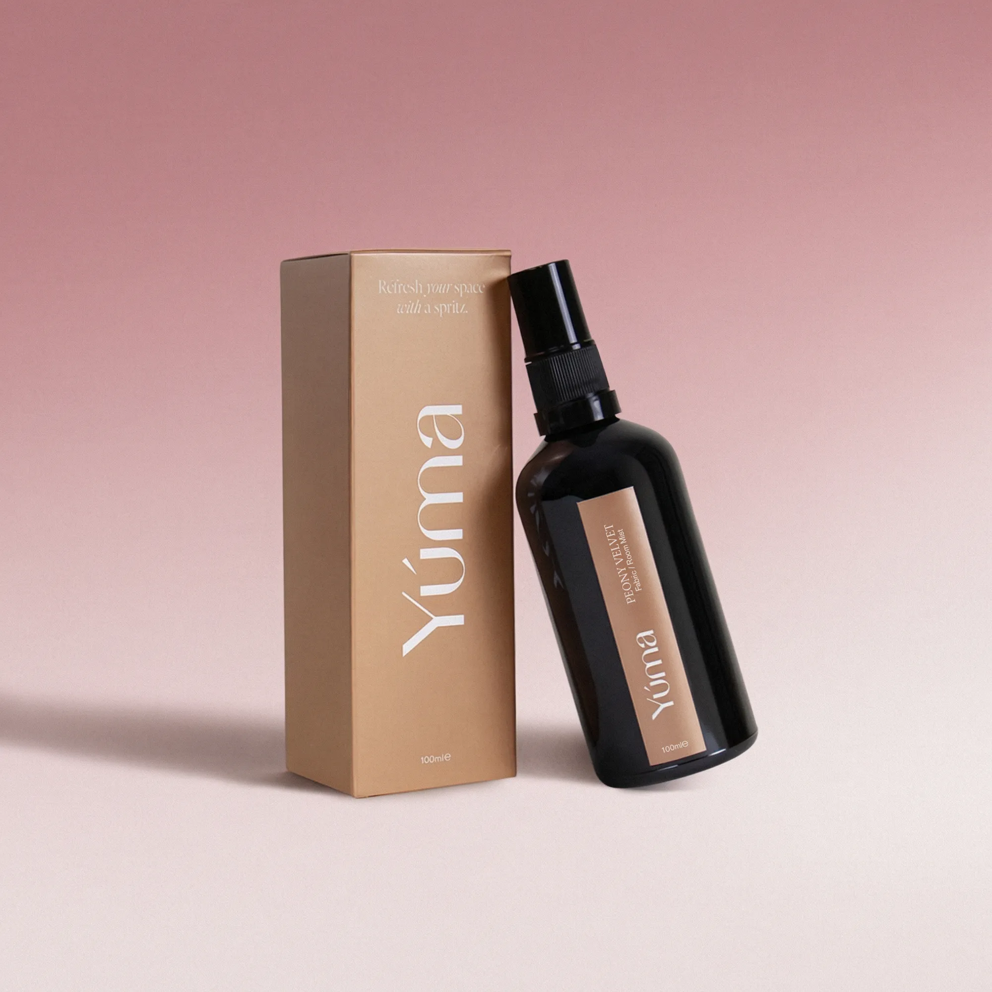 Peony Velvet Fabric Mist Μαύρο μπουκάλι Fabric Mist Peony Velvet της YUMA δίπλα στην μπεζ χάρτινη συσκευασία του.