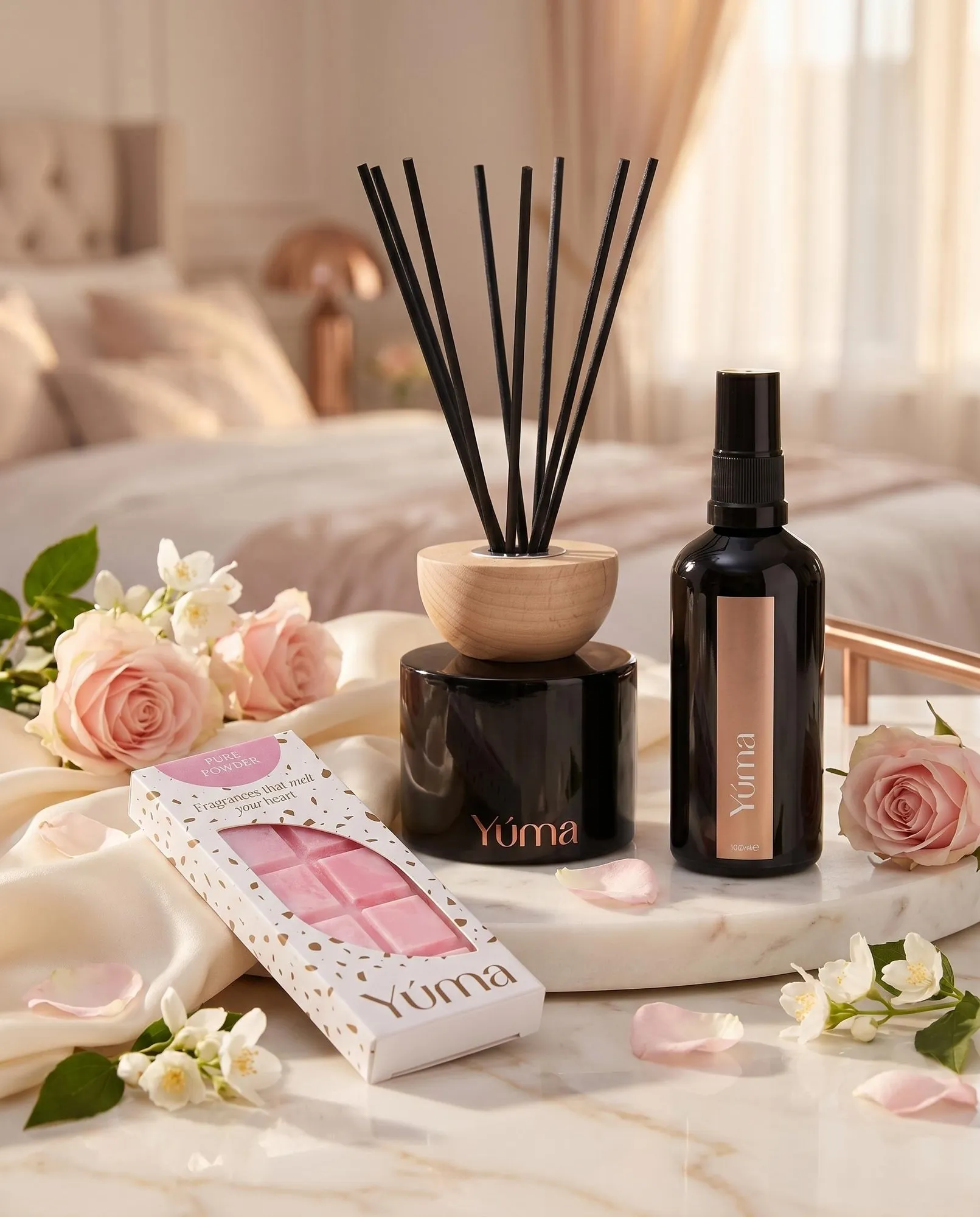 Bedroom Set Reed Diffuser, Fabric/Room Mist και Pure Powder Snap Bar της YUMA δίπλα σε ροζ τριαντάφυλλα.