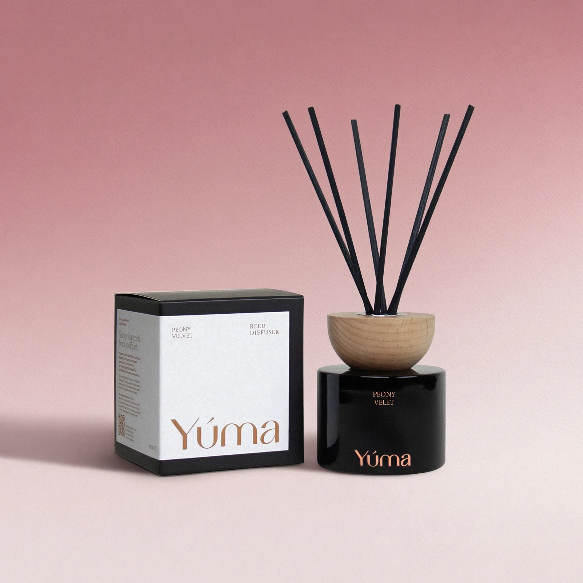 Peony Velvet Reed Diffuser Μαύρο Reed Diffuser Peony Velvet της YUMA με ξύλινο καπάκι και μαύρα στικ δίπλα στη συσκευασία του.