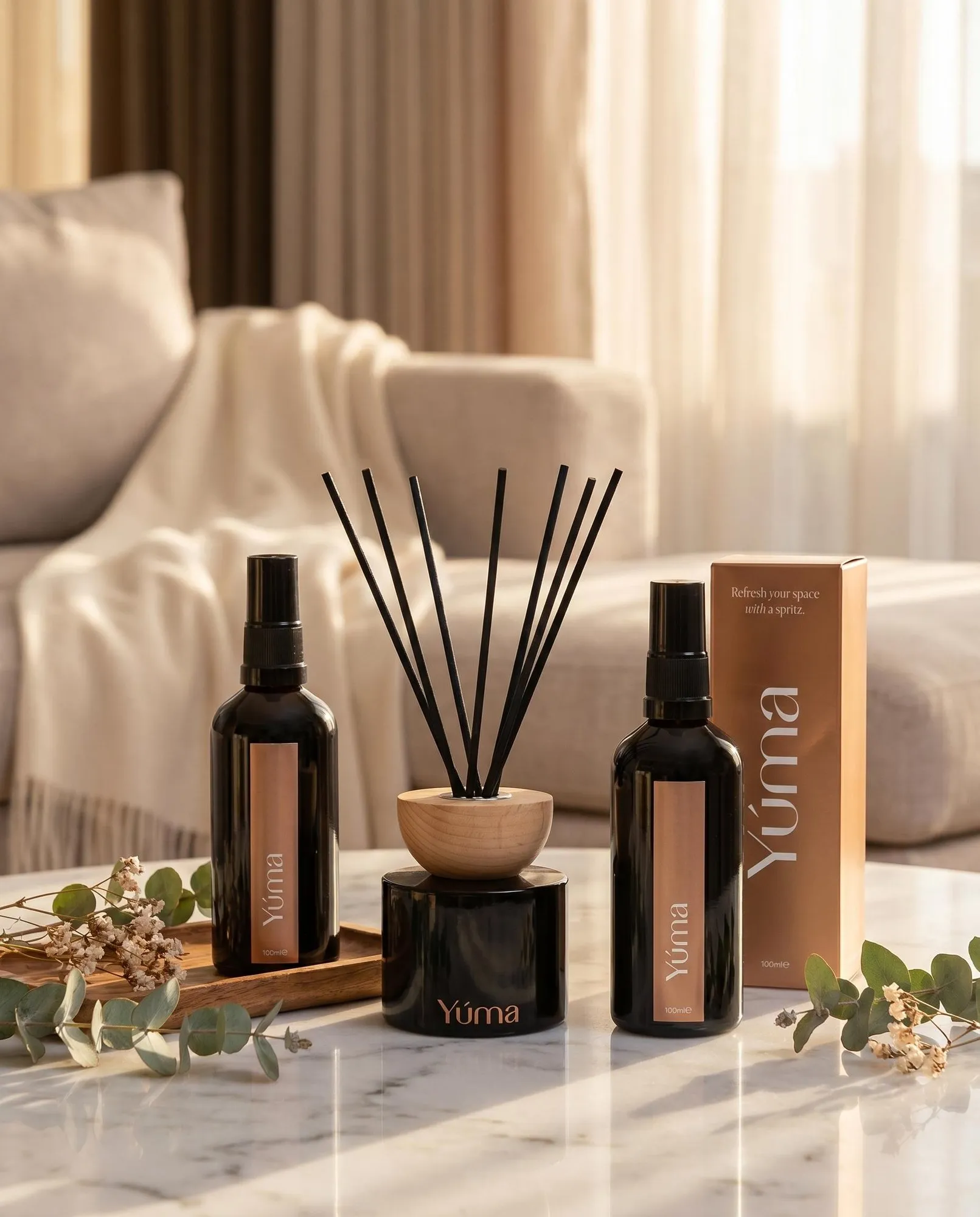 Anti Tobacco Room Set Δύο room sprays και ένα reed diffuser της YUMA σε μαύρα μπουκάλια πάνω σε μαρμάρινο τραπέζι.
